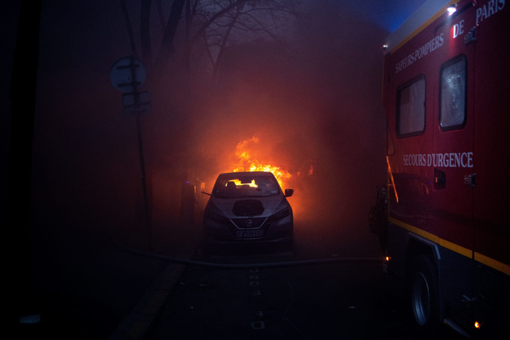 Une voiture en feu et un camion de pompier dans la fumée d'une agence bancaire incendiée durant la manifestation du 5 décembre contre la proposition de loi dite Sécurité globale à Paris