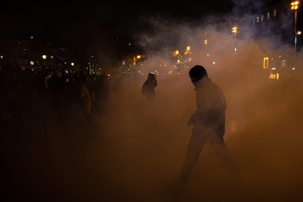 Un homme sort d'un nuage de gaz lacrymogène place de la République à Paris lors d'affrontements entre manifestants et policiers à la fin de la manifestation contre la proposition de loi dite Sécurité Globale le 5 décembre 2020.