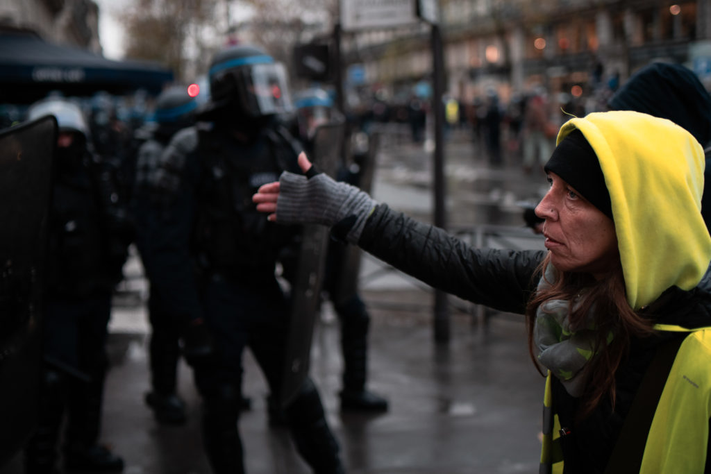 Une manifestante arborant un gilet jaune demande ux policier si "ils n'ont pas honte de charger gratuitement le cortège" lors de la manifestation contre la proposition de loi dite Sécurité Globale le 12 décembre 2020.