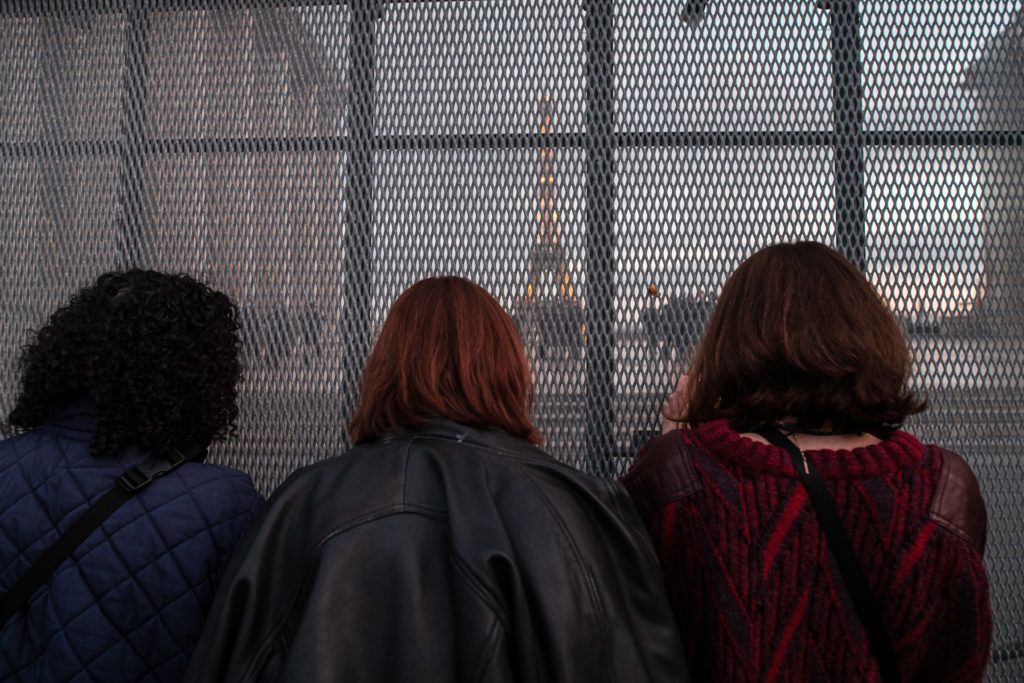 Le 21 novembre 2020, un groupe de femmes prend des photos des CRS sur le parvis des droits de l'homme derrière une barrière en métal, pendant la manifestation contre la proposition de loi Sécurité globale