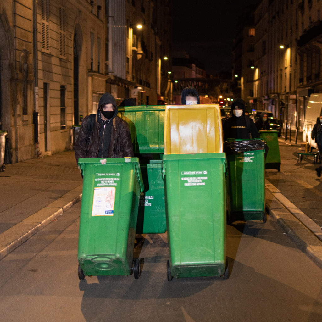 Un policier intime aux CRS de ne pas descendre trop brusquement un lycéen d'une pile de poubelle lors de la tentative de blocus du lycée Colbert dans le 10ème arrondisssement de Paris le 26 janvier 2021