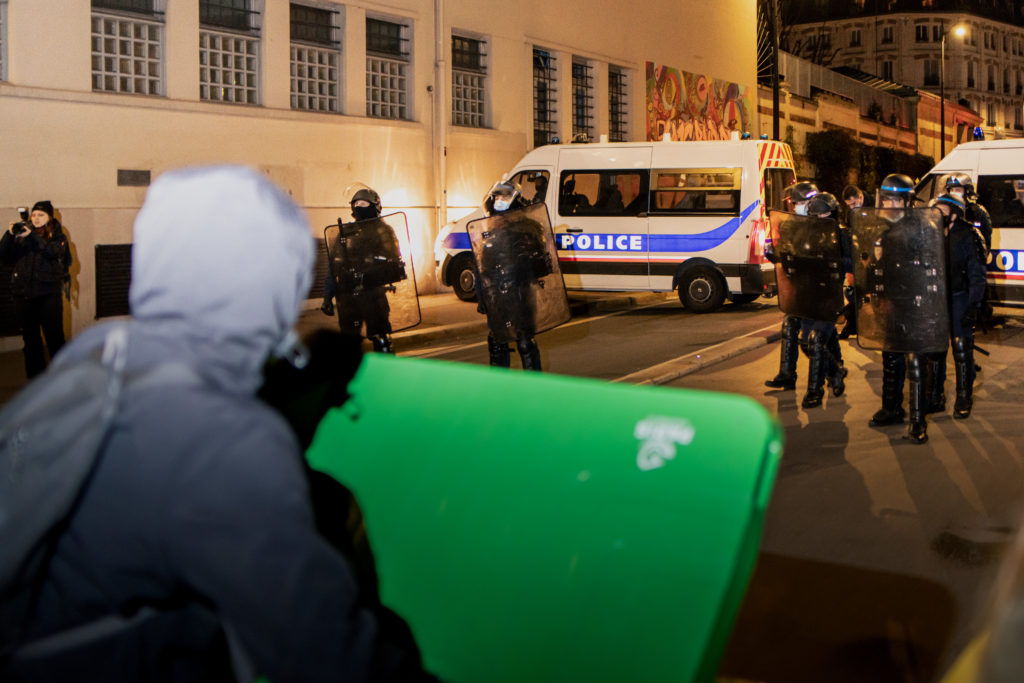 Des lycéens font face à la police avec des poubelles devant le lycée Colbert dans le 10ème arrondissement de Paris lors d'une tentative de blocus le 26 janvier 2021