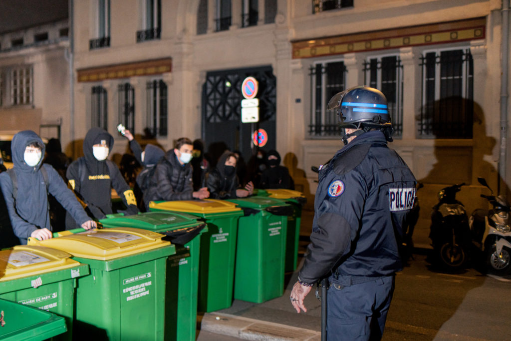 Un policier parlementente avec les lycéens qui souhaitent bloquer le lycée Colbert dans le 10ème arrondissement de Paris le 26 janvier 2021