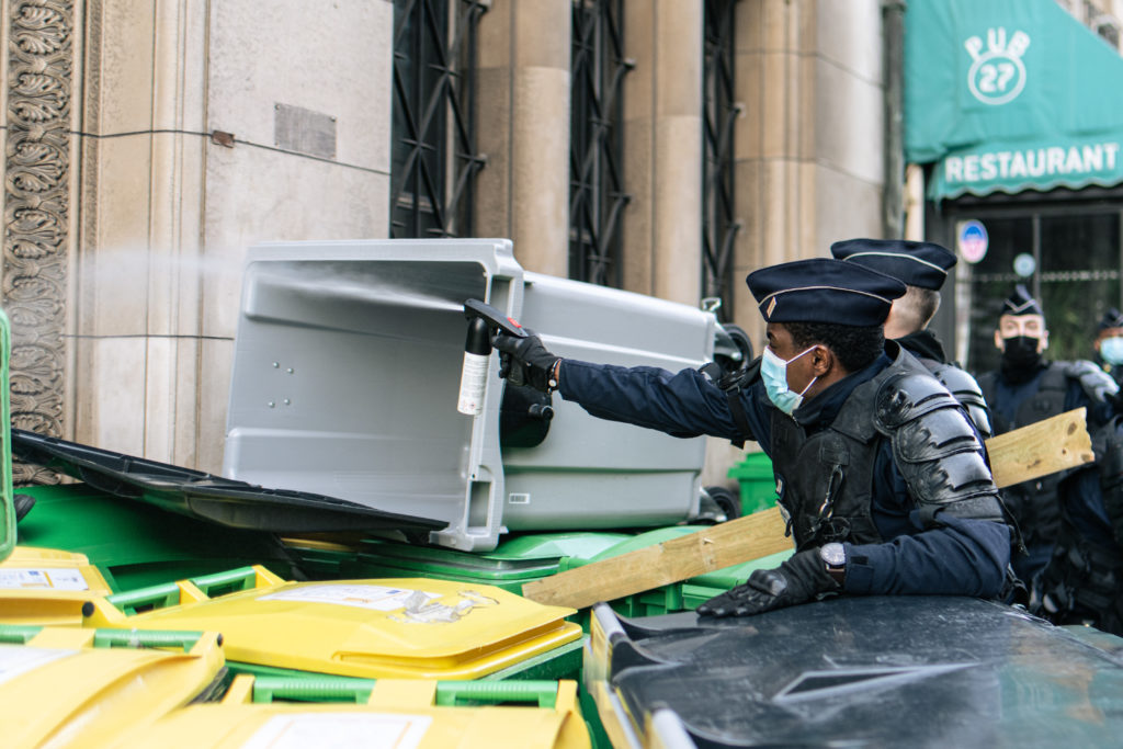 Un policier tire à la bombe lacrymogène en direction d'un lycée qui se réfugie dans le lycée Racine lors d'une tentative de blocus le 26 janvier 2021