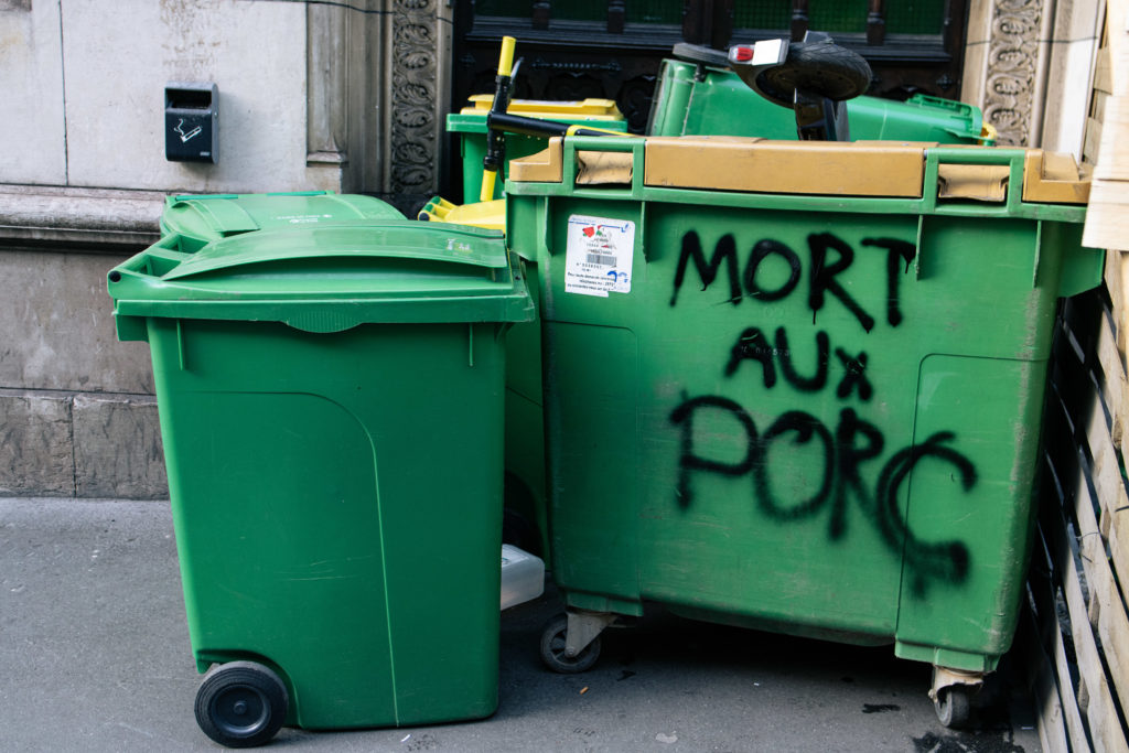 Des poubelles, dont une avec un tag "mort aux porc" suite à une tentative de blocus au lycée Racine à Paris le 26 janvier 2021