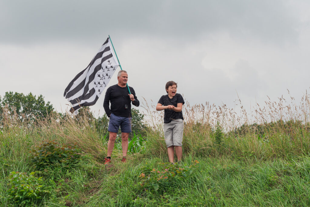 Un père arborant le drapeau breton accompagné de son fils pendant l'épreuve contre la montre entre Changé et Laval en Mayenne lors du Tour de France 2021