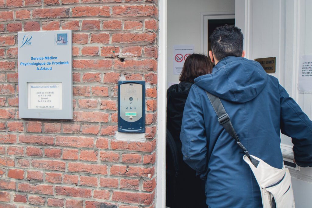 Claire Gibour, infirmière de l'EMOT et sa collègue, accompagnent un patient dans un service médico-psychologique de proximité pour qu'il reçoive un traitement.