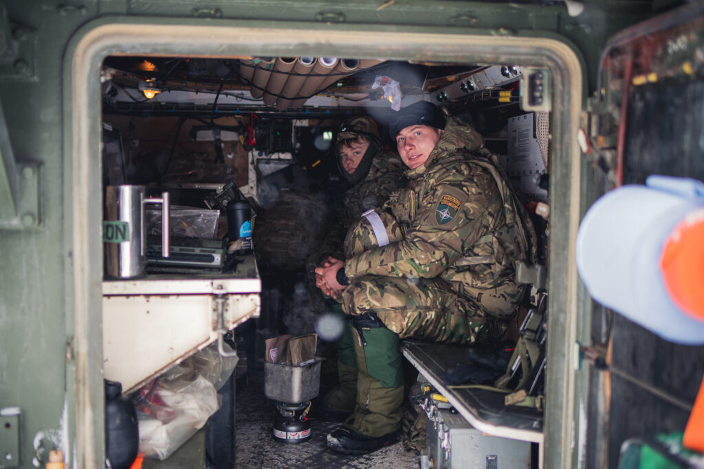 Un caporal britannique prépare le déjeuner dans un véhicule blindé britannique, le 5 février 2022, lors du Winter Camp de l'eFP Battlegroup en Estonie.