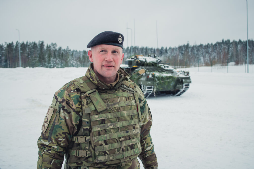 Le lieutenant colonel brittanique Simon Worth, commandant du Battlegroup eFP en Estonie devant un char pendant le Winter Camp organisé par l'OTAN et les forces estoniennes, le 5 février 2022