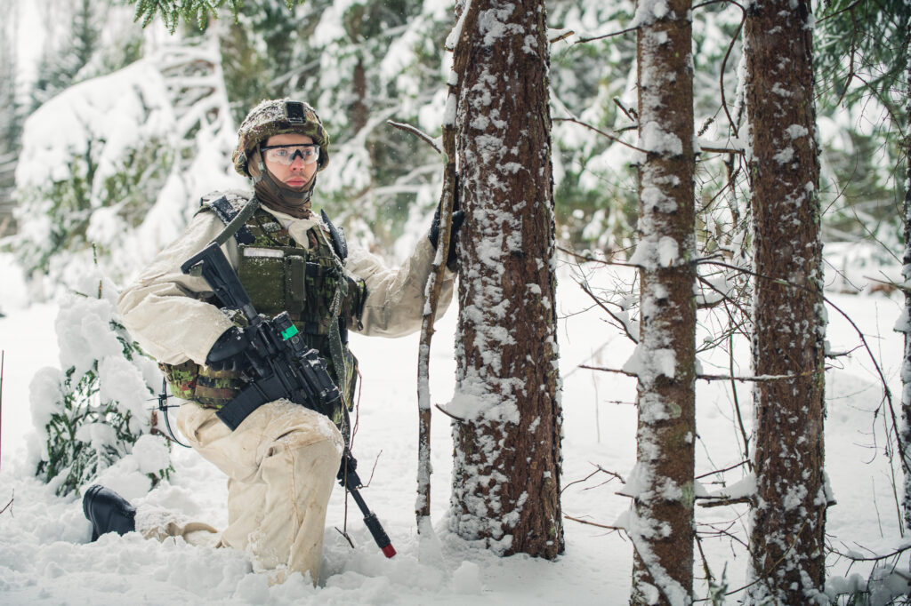 Un combattant de l'infanterie estonienne se tient prêt armé d'un fusil mitrailleur, le 6 février 2022, lors du Winter Camp de l'enhanced Foward Presence Battlegroup de l'OTAN en Estonie.