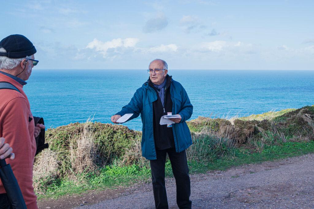 Un membre du collectif contre les éoliennes en baie de Saint Brieuc distribue des tracts et sensibilise les visiteurs venus voir le départ de la route du Rhum sur le cap Fréhel le 9 novembre 2022.